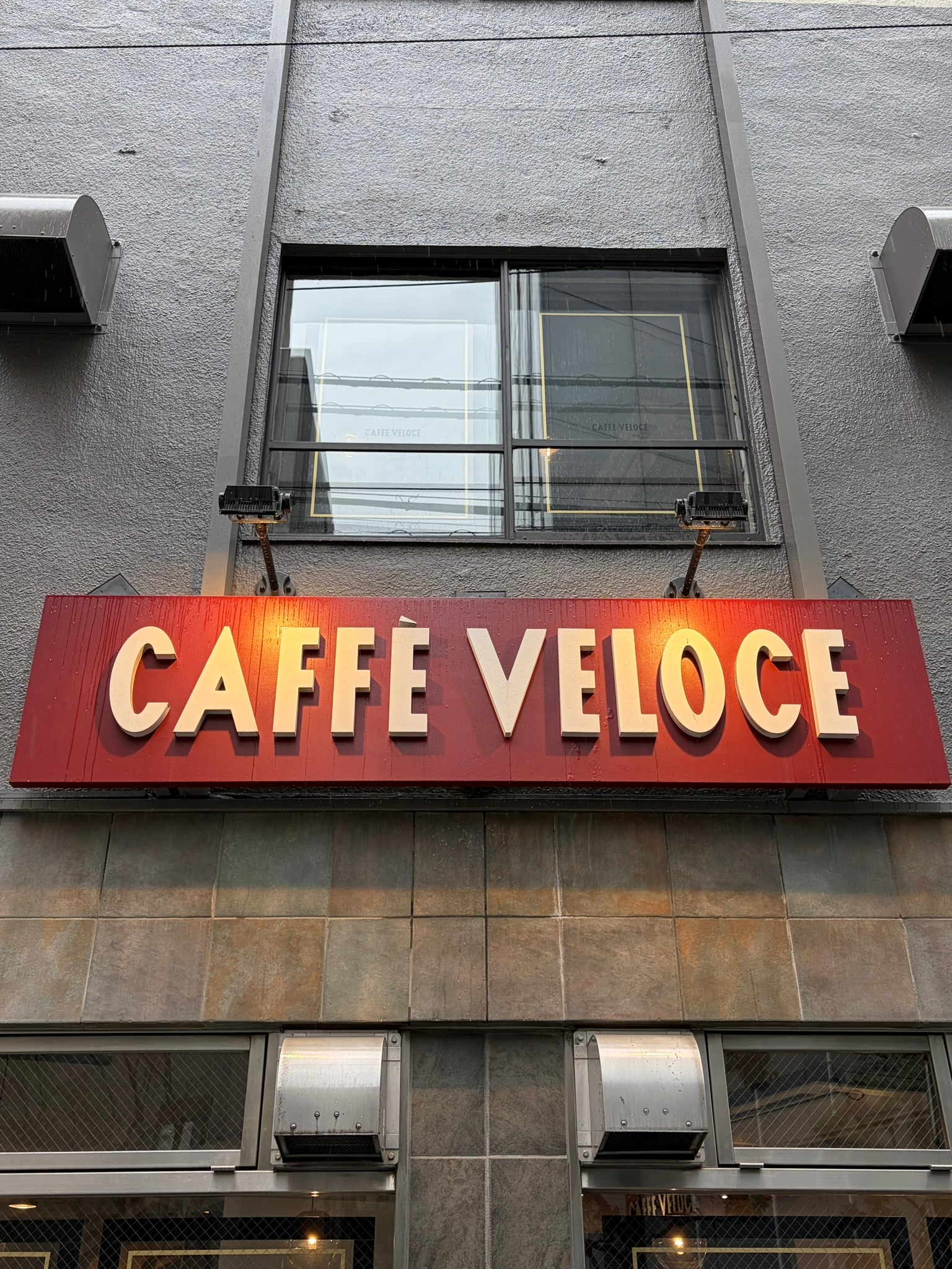 カフェベローチェの店頭看板が見えるビル外観。