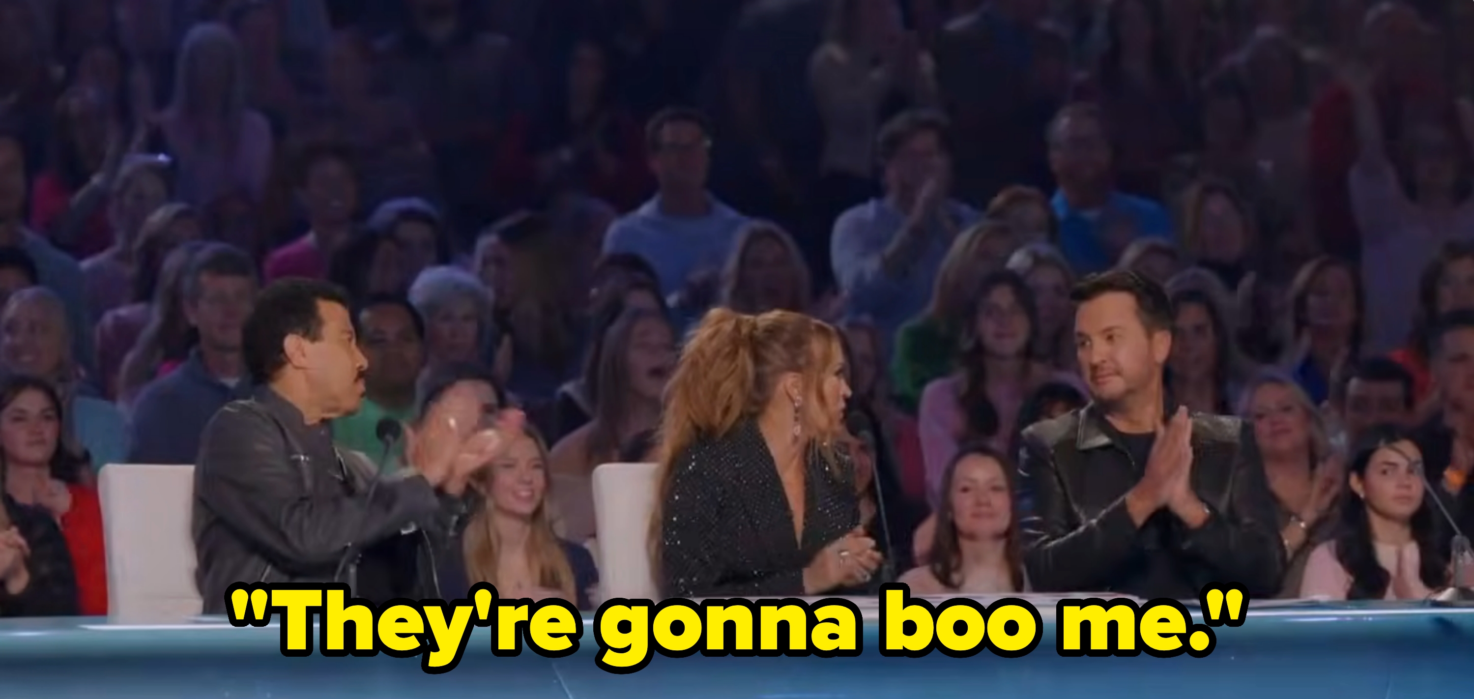 Lionel Richie, Carrie Underwood, and Luke Bryan successful stylish outfits clap connected American Idol with an assemblage successful the background