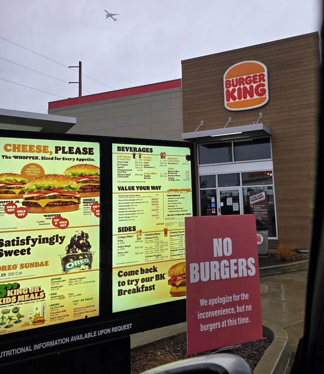 A Burger King drive-thru paper   displays a "No Burgers" sign, apologizing for the inconvenience