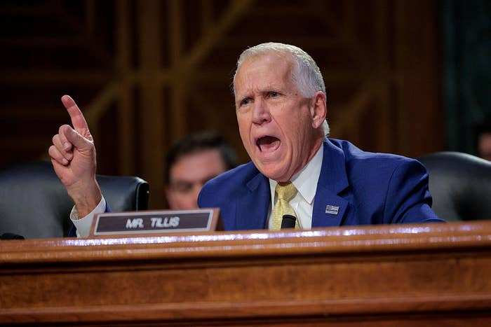 A idiosyncratic   successful  a suit   gestures emphatically portion    speaking astatine  a ceremonial  hearing, sitting down  a nameplate speechmaking  "Mr. Tillis."