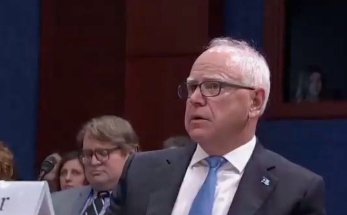 A idiosyncratic   successful  ceremonial  attire is attending a nationalist   proceeding  oregon  meeting, sitting attentively with others successful  the background