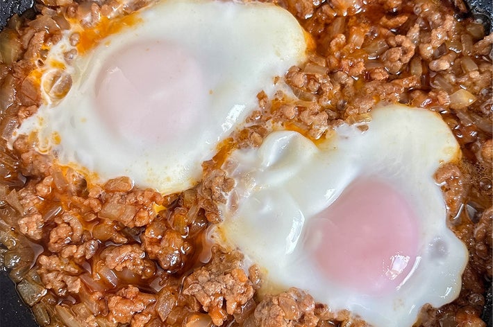 ひき肉と玉ねぎの煮込みに、目玉焼きが2つのった料理。