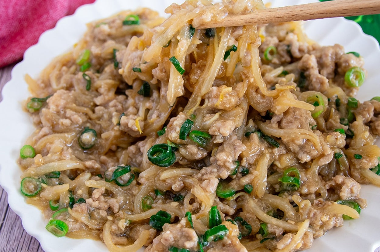 皿に盛られた、ひき肉とネギを使ったもやし料理。箸で持ち上げられている。