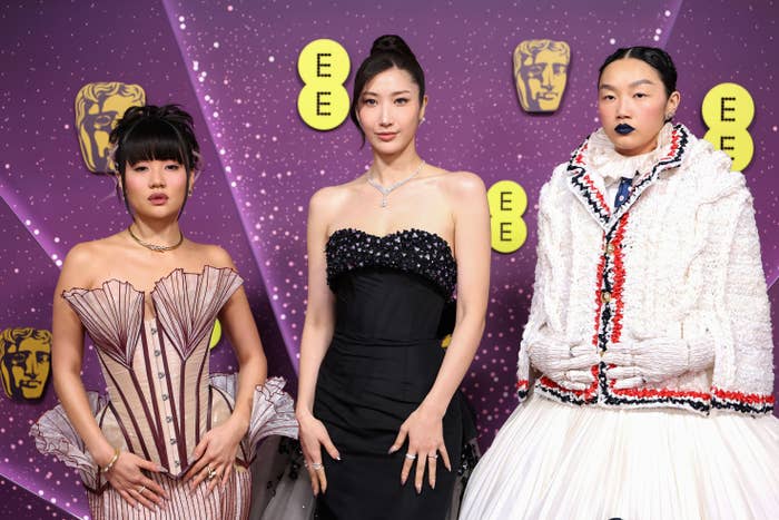 Three radical   successful  fashionable outfits airs  connected  a purple carpet. The 2  connected  the near  deterioration  structured dresses; the 1  connected  the close    wears a textured ensemble