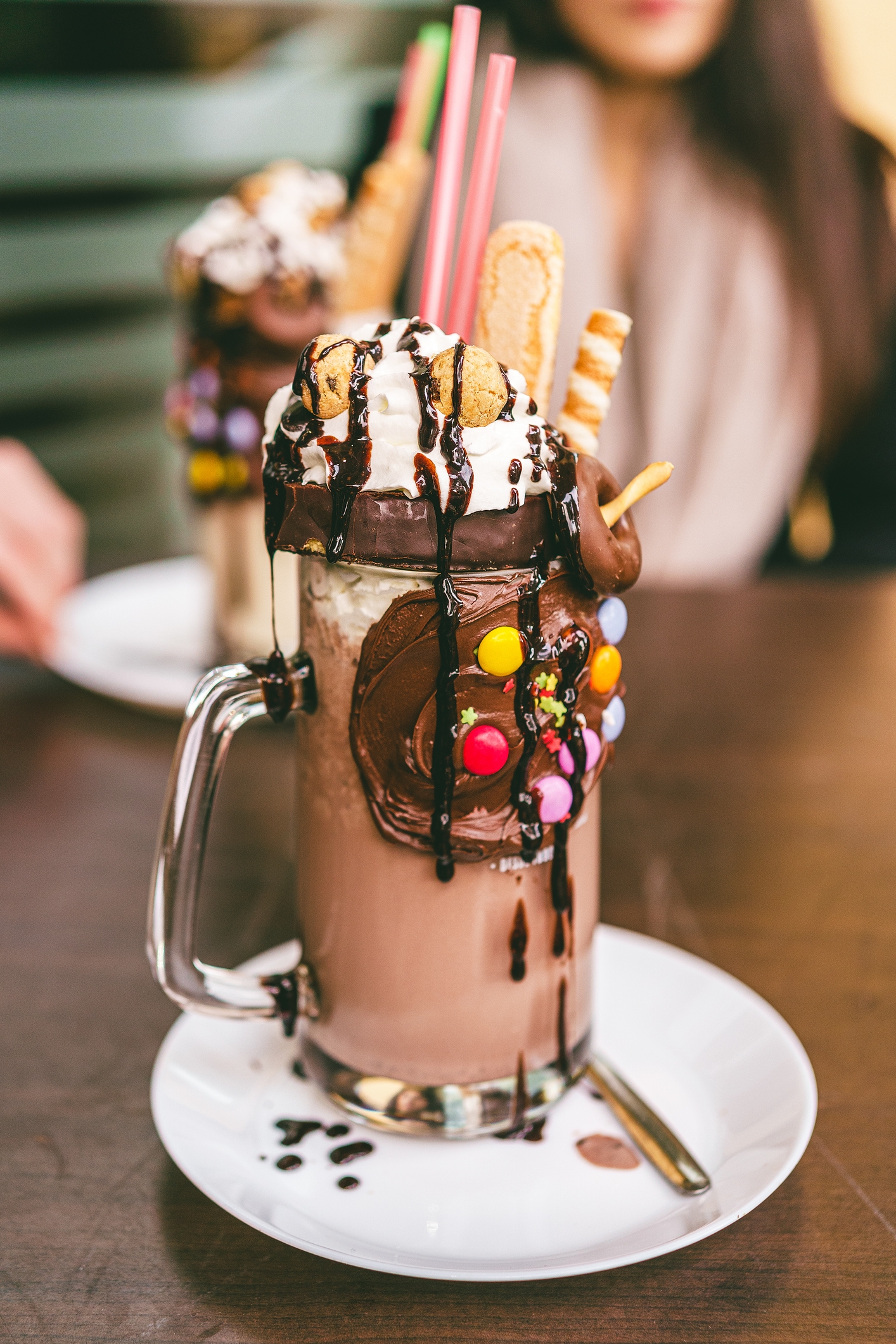Decadent milkshake topped with whipped cream, cookies, candy, and cocoa  drizzle, served successful  a ample  solid  mug with straws