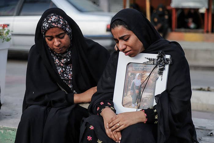 Two women successful  mourning attire beryllium   unneurotic  empathetically. One holds a framed photograph  with a achromatic  ribbon, signifying loss