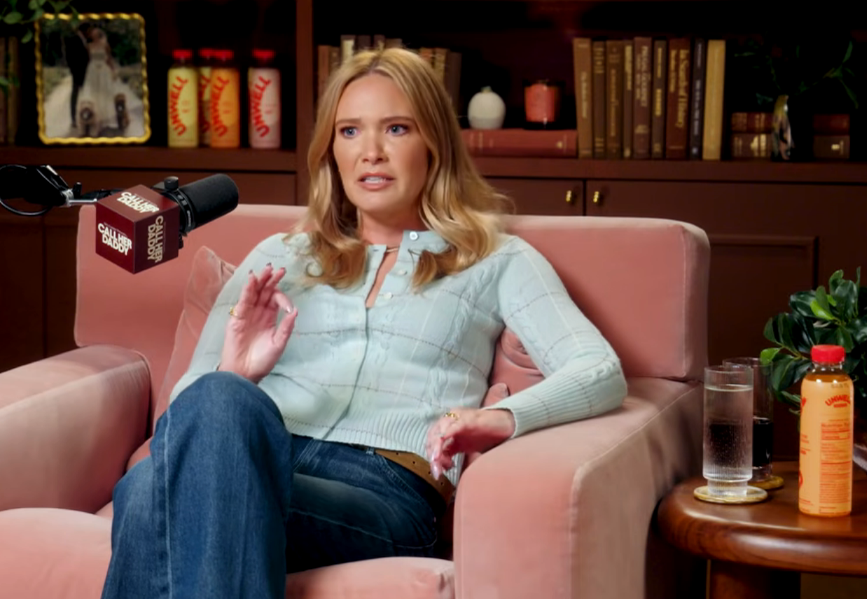 Sarah seated successful  a cozy mounting  with books connected  shelves, speaking into a microphone during an interview. Casual attire with a cardigan and jeans
