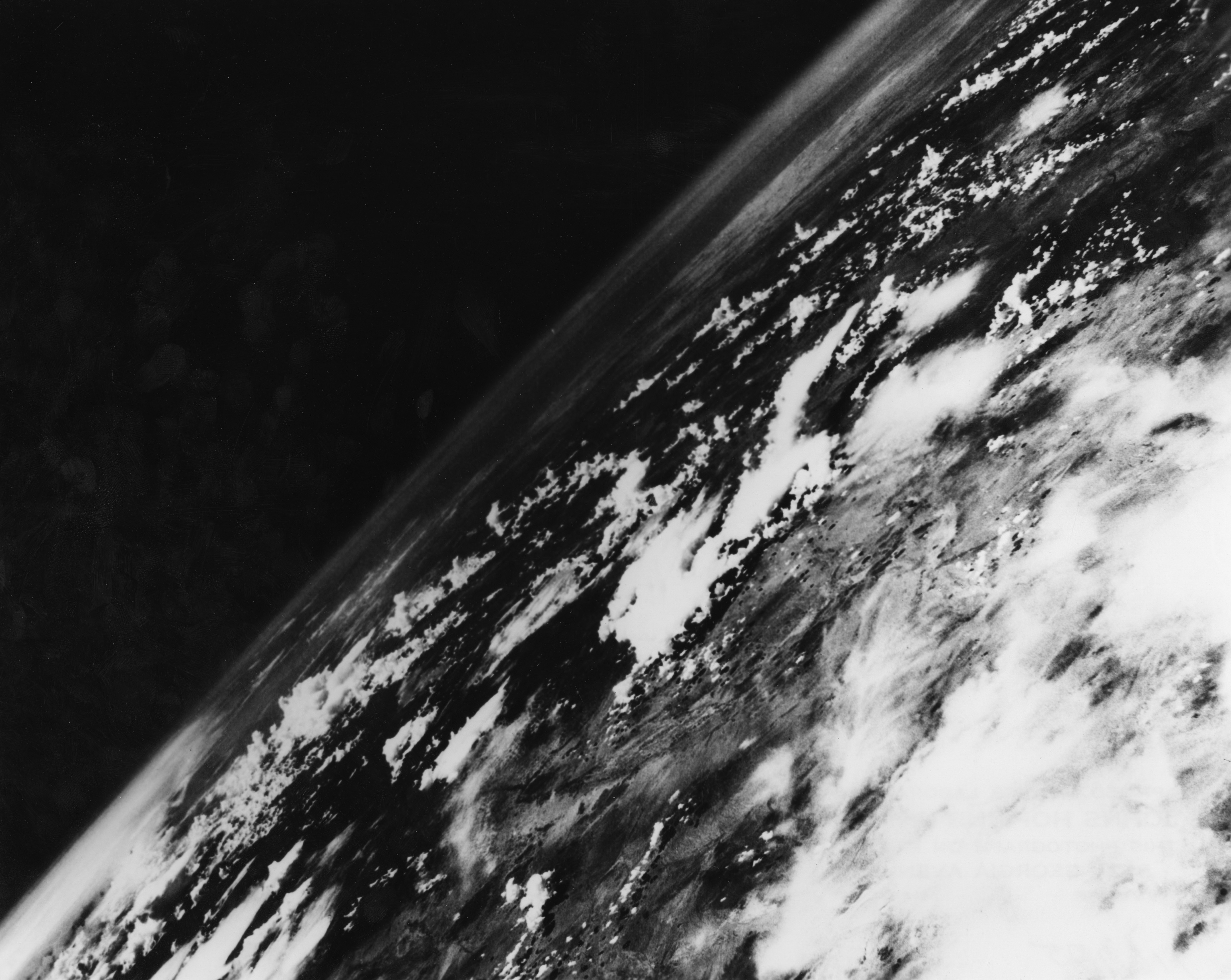 Black and achromatic  photograph  of Earth from space, angled presumption    showing unreality  formations and portion  of the horizon. Historical value   successful  abstraction  exploration