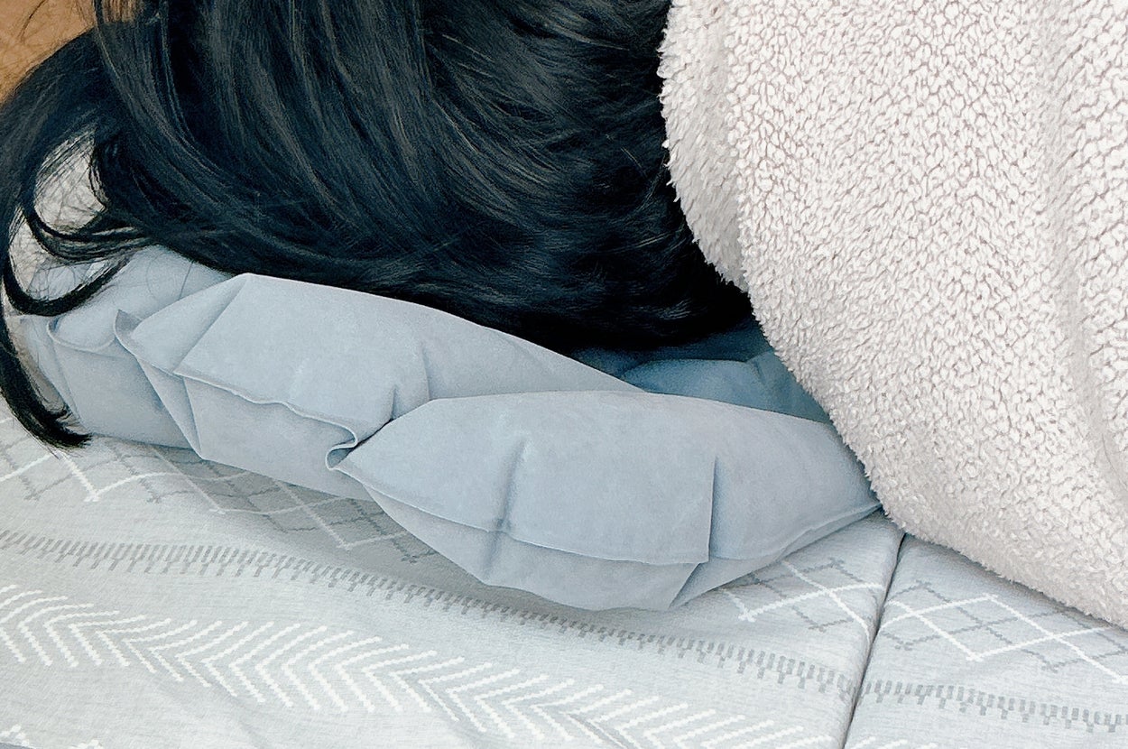 男性がマットに横たわり、枕を使って寝ています。