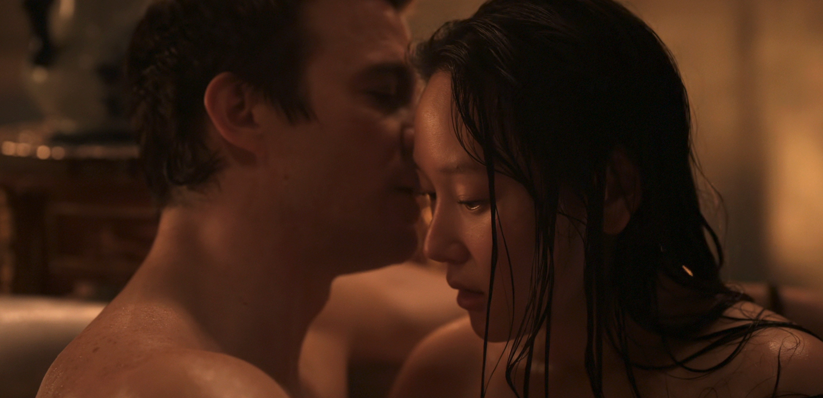 A couple embraces intimately in a dimly lit room, sharing a quiet moment together, highlighting themes of connection and emotion