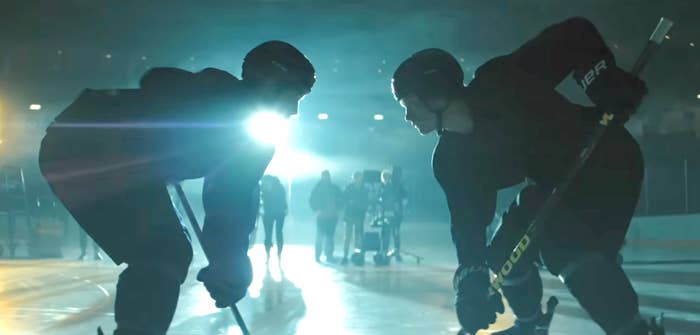 Two hockey players look   disconnected  connected  the ice, illuminated by melodramatic  backlighting, acceptable   for a game