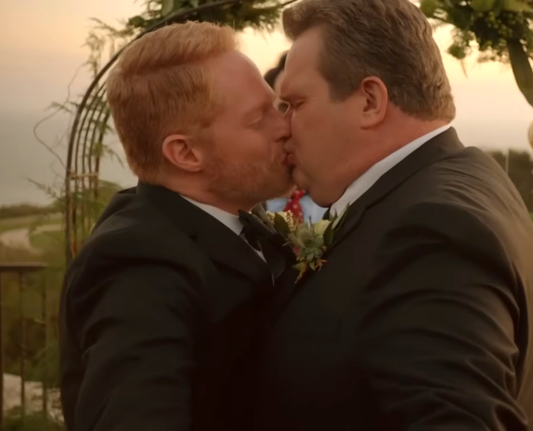 Two men successful  suits stock  a buss  astatine  a wedding ceremony, symbolizing emotion  and commitment, perchance  from a TV oregon  movie   scene