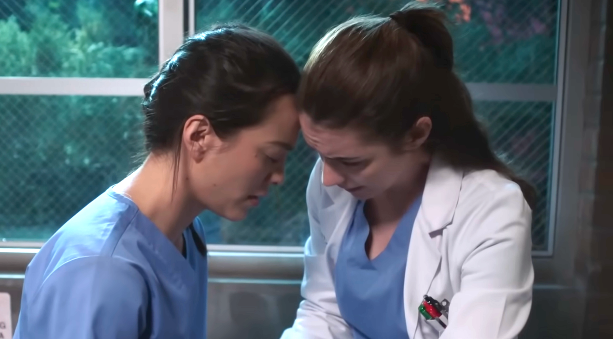 Two actors successful  a infirmary  scene, 1  successful  bluish  scrubs and the different   successful  a laboratory  coat, stock  an affectional  moment, touching foreheads