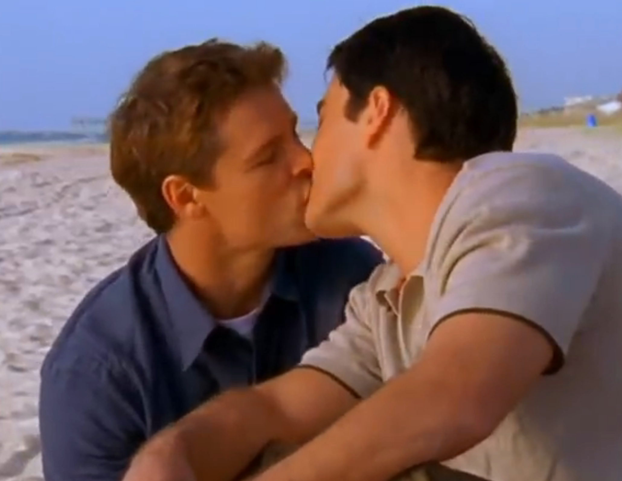 Two radical   buss  connected  a beach, sitting closely, creating an intimate moment