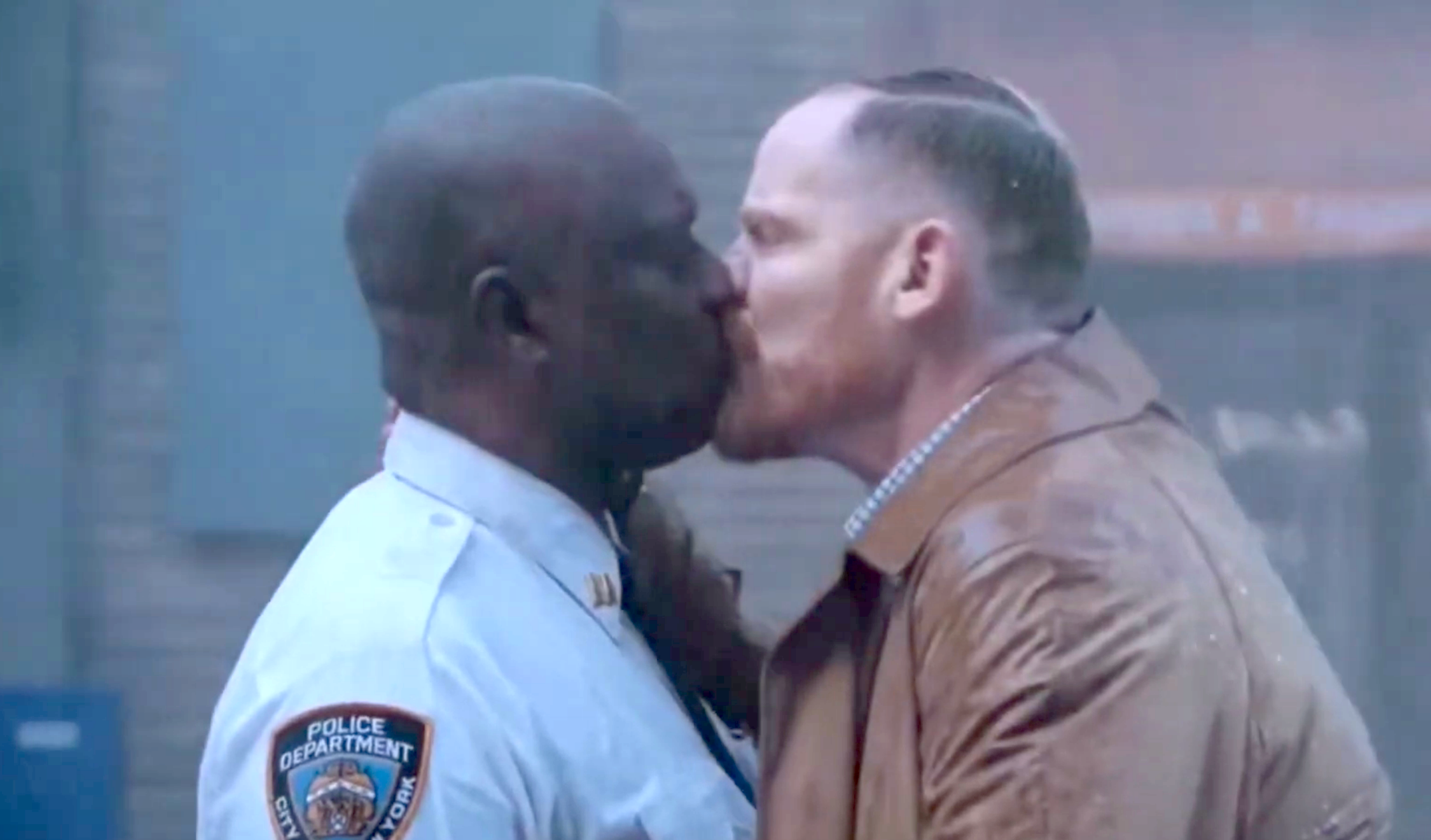 Two men are kissing; 1  wears a constabulary  uniform, the different   a trench coat. The country   suggests an affectional  moment, apt  from a TV amusement   oregon  movie