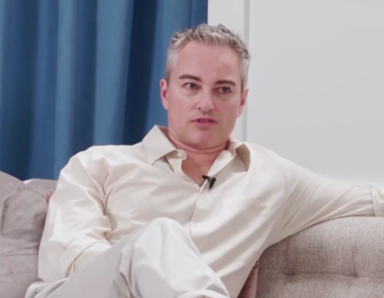 Person successful  a casual garment  and pants sitting connected  a couch, speaking during a TV interview