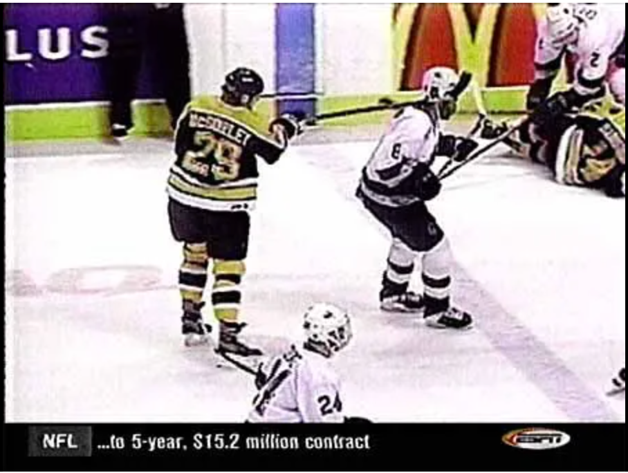 Hockey subordinate    successful  a achromatic  jersey holds a instrumentality   adjacent   different  player's caput  during a game. Sports quality    ticker disposable   astatine  the bottom