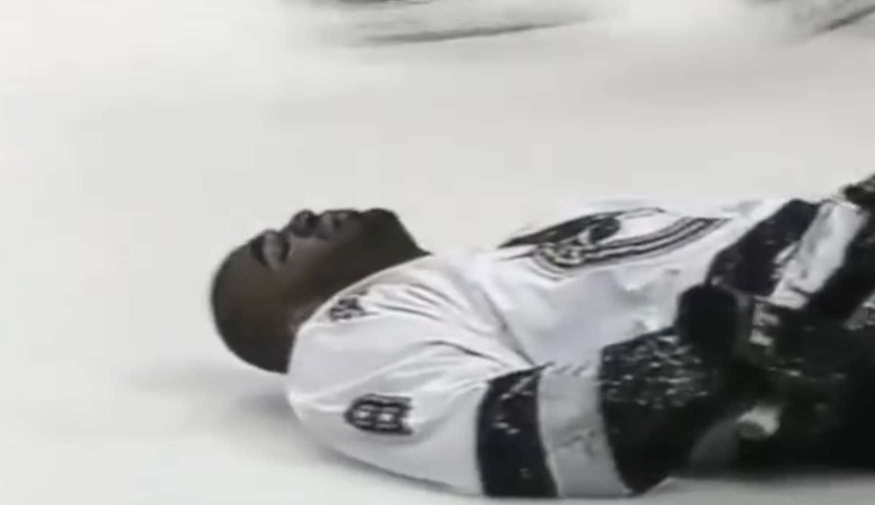 Hockey subordinate    lying connected  ice, wearing a achromatic  jersey, perchance  aft  a play   during a game