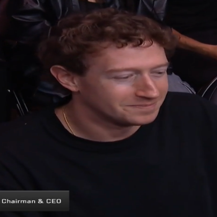 Mark Zuckerberg seated at a sports event, wearing a casual t shirt