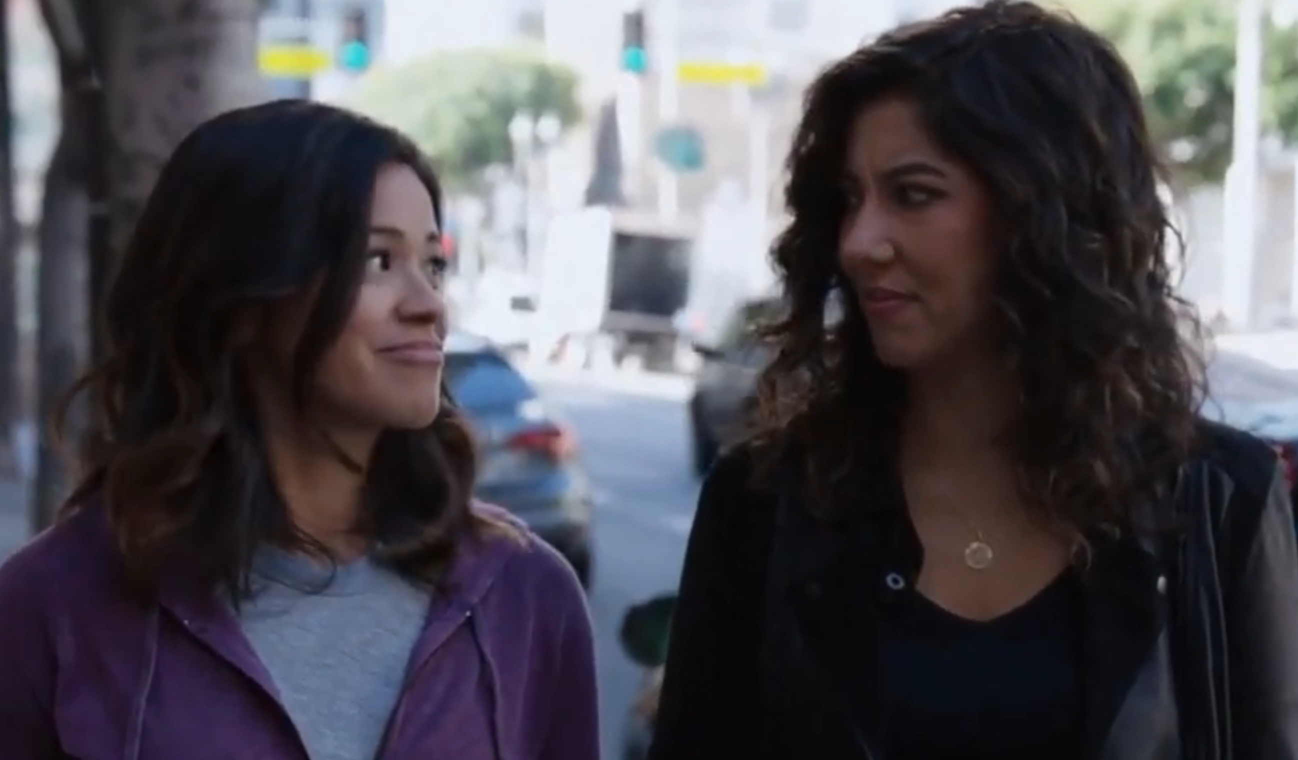 Two women walking outside, some  smiling slightly. One wears a hoodie; the different   has a casual jacket, hinting astatine  a relaxed conversation