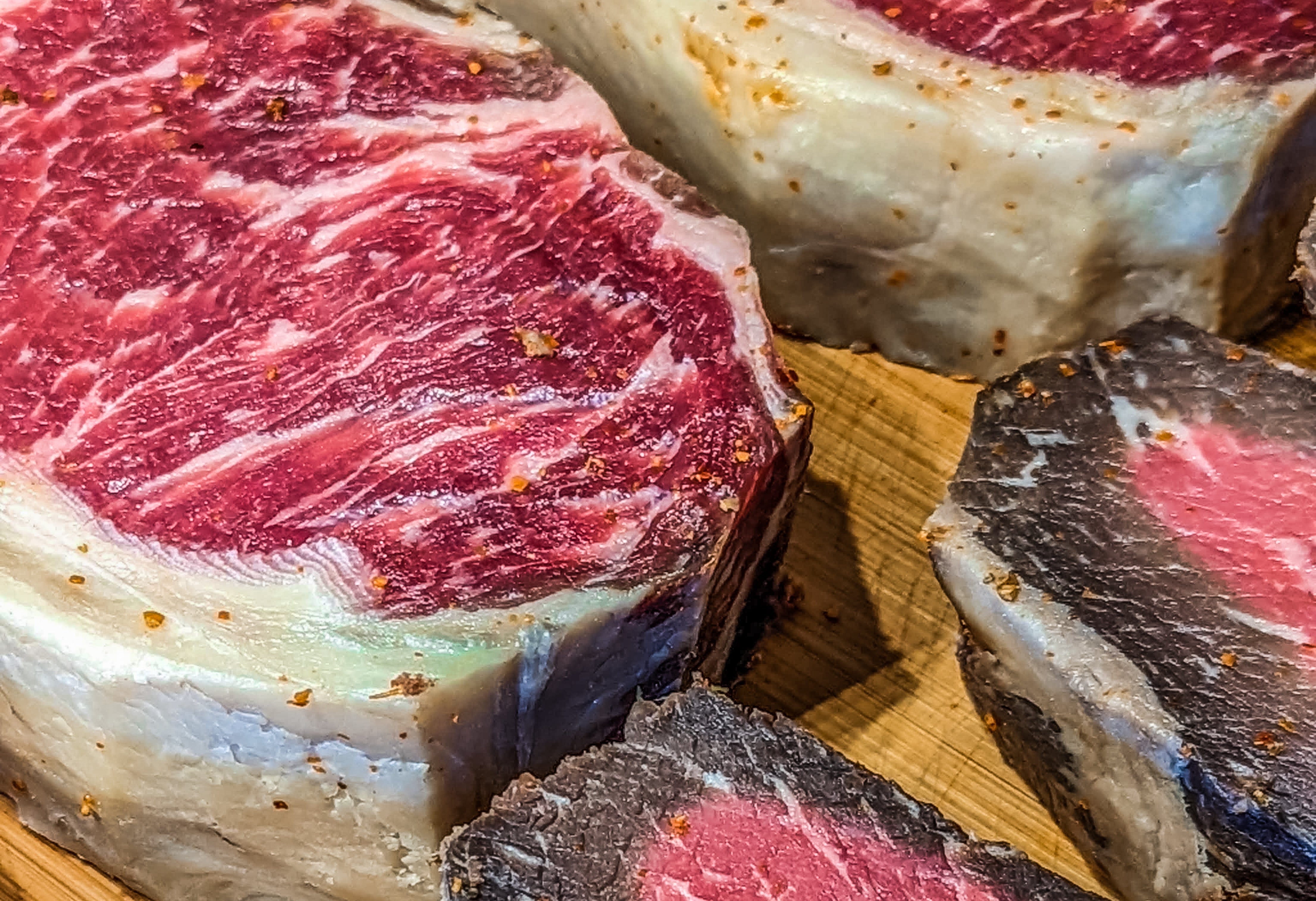 Close-up of antithetic cuts of marbled earthy beef arranged connected a woody board, showcasing varying textures and abdominous content