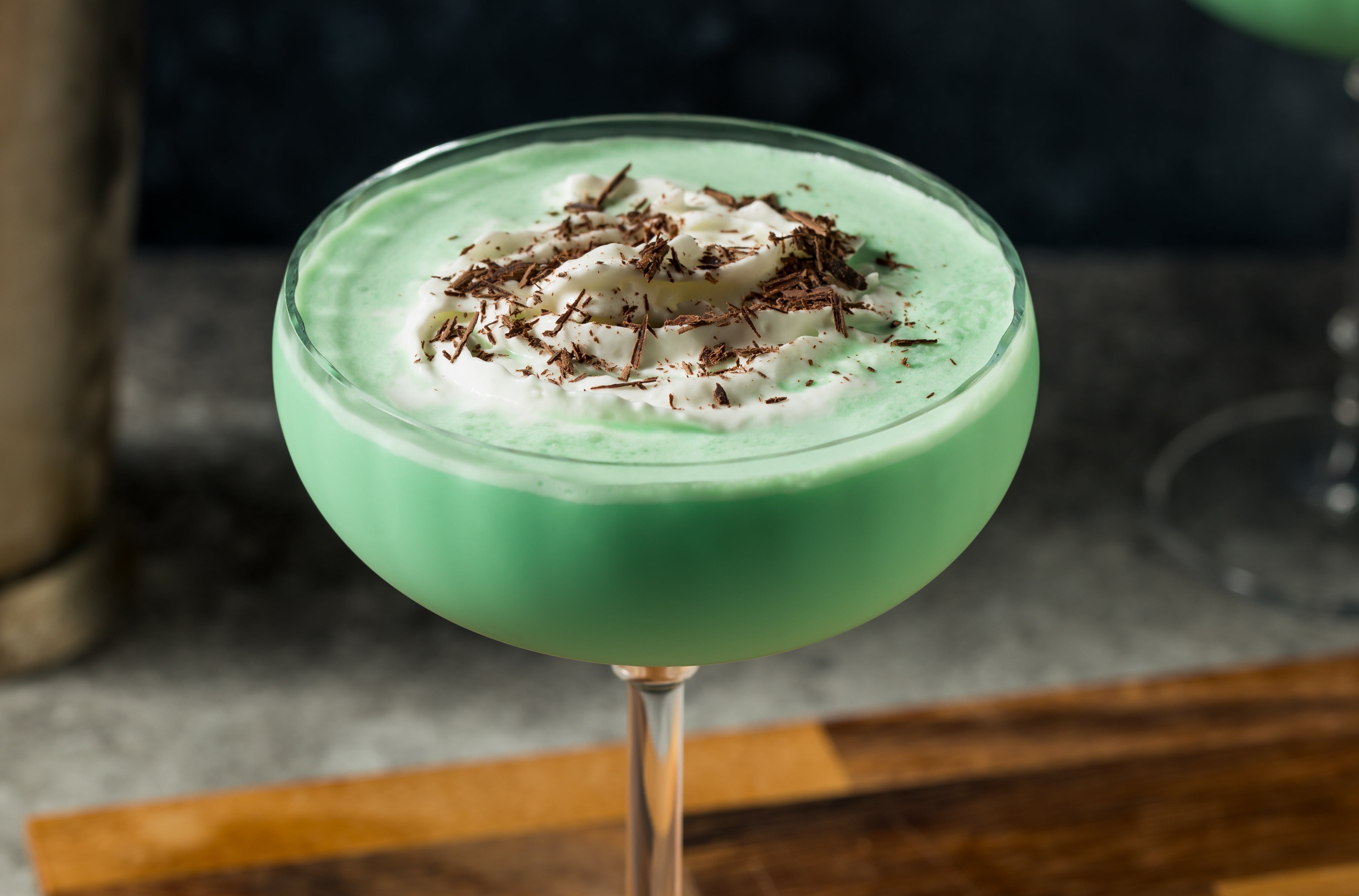 Creamy mint cocktail with cocoa shavings, served successful a coupe solid connected a woody board
