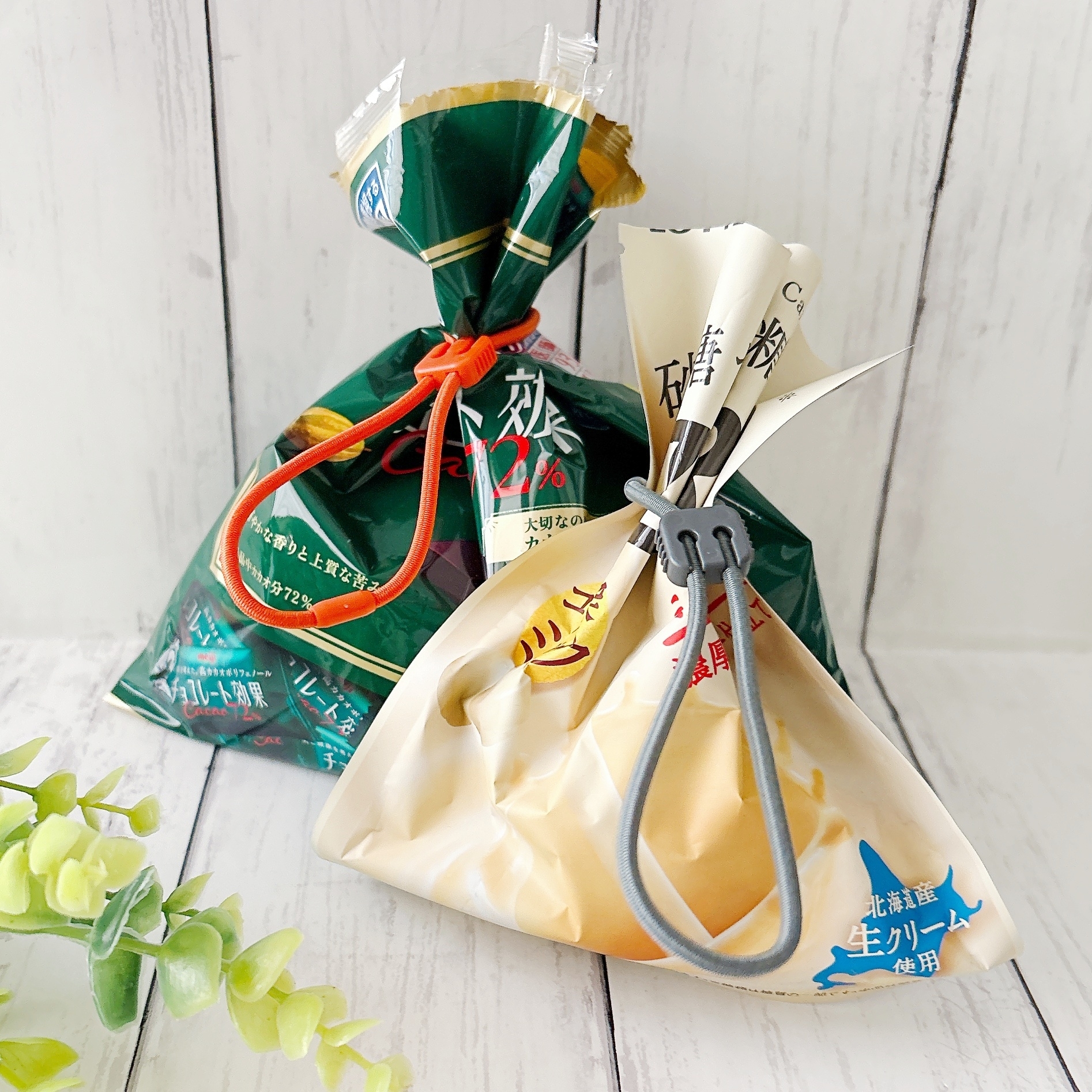 テーブル上に2つの日本のパン袋があり、それぞれ異なるデザインの留め具で閉じられています。