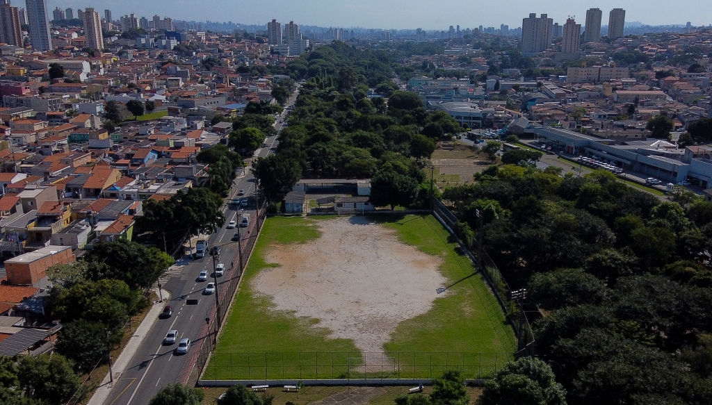 Aerial presumption    of an municipality  sports tract  surrounded by metropolis  buildings and trees, with roads and postulation   connected  the near  side