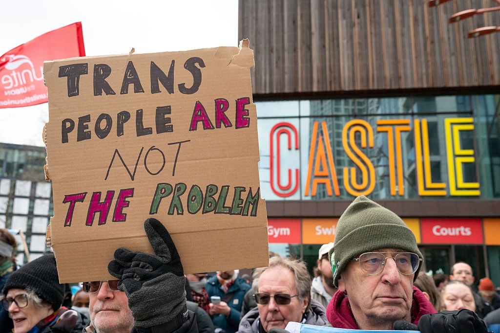 En folkemengde ved en protest holder et skilt der det står 