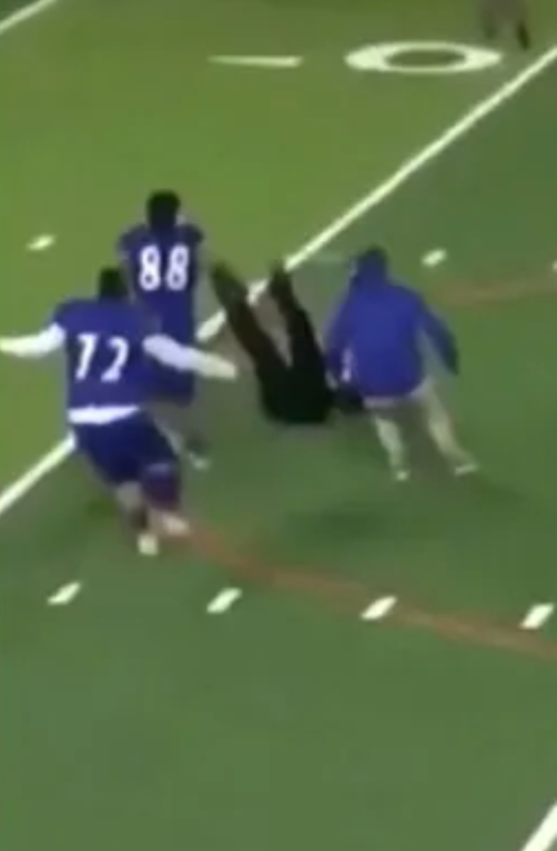 Football subordinate    tackled connected  tract  by 2  opponents during a game