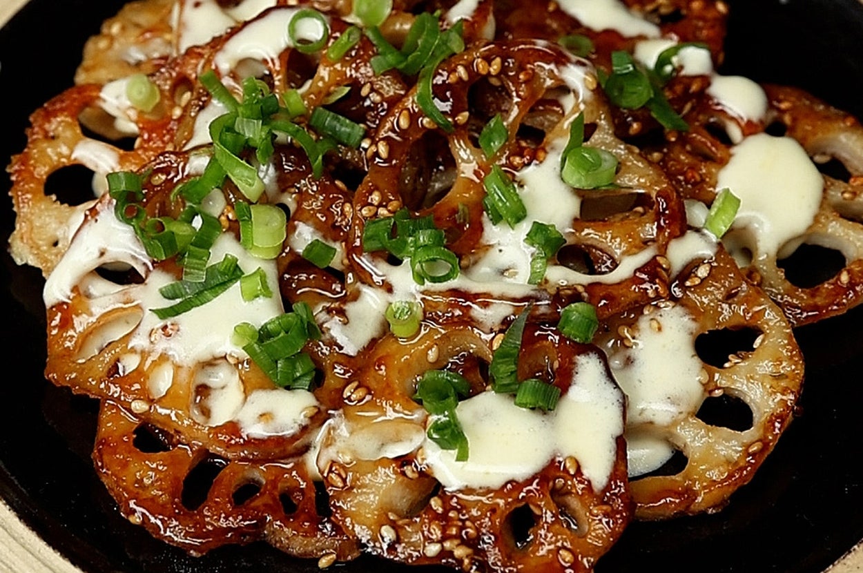 レンコンのフライにソースとネギをのせた料理が皿に盛られている。