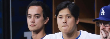 野球チームのベンチで考え込む選手たちの様子。ダグアウトにいる選手たちは試合の様子を見守っている。