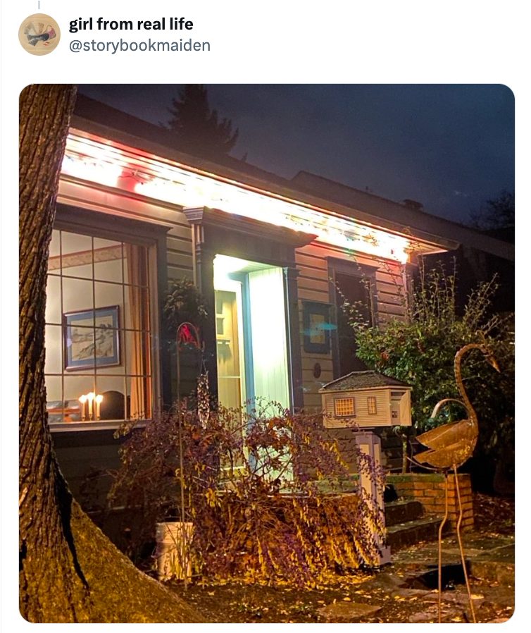 A cozy location   with candles successful  the window, surrounded by foliage and a flamingo tract   ornament, astatine  dusk with a glowing structure  light