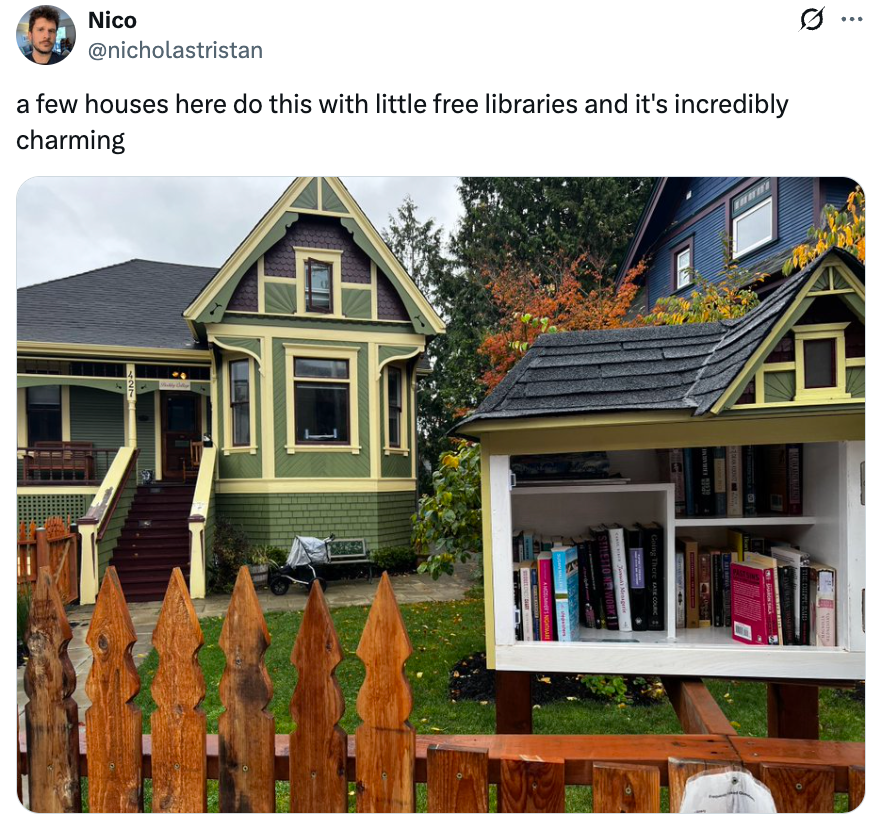 A quaint vicinity  country   with a historic-style location   and a tiny  outdoor escaped  room  filled with books, alongside a woody  fence