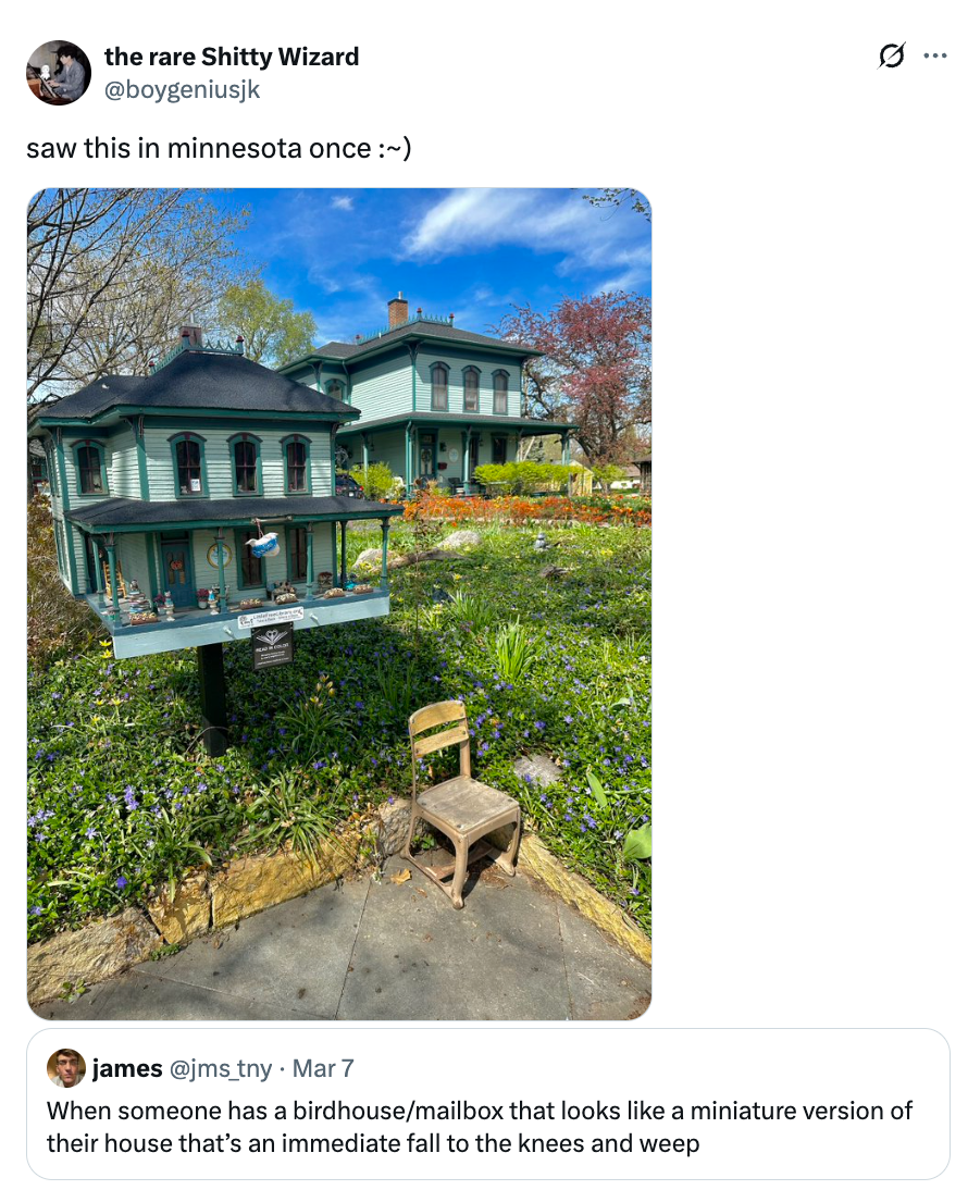 A ample  birdhouse resembling a miniature mentation    of a adjacent    historic-style house, surrounded by a plot  with a tiny  seat  successful  front