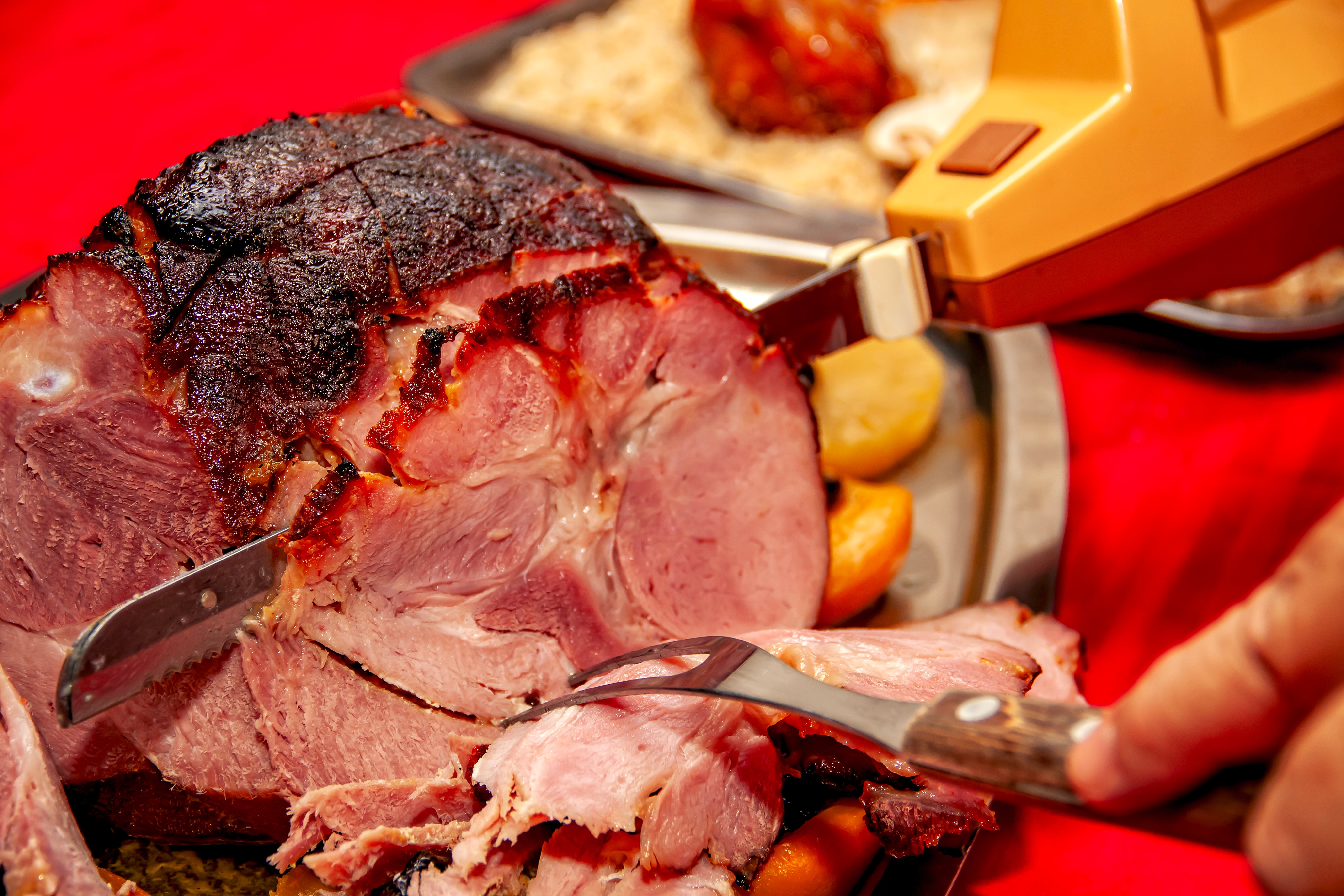 Sliced ham being chopped  with an electrical  knife