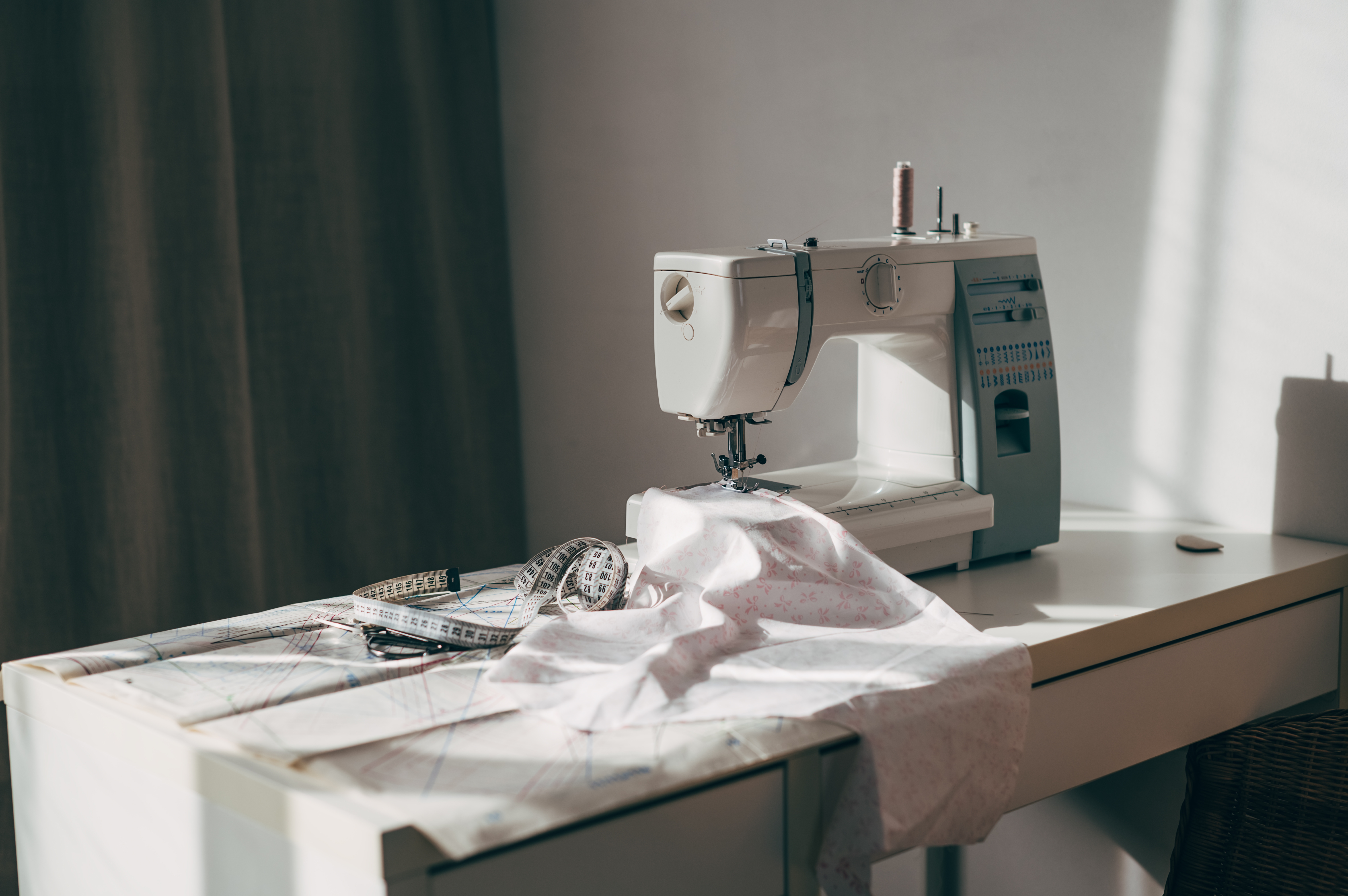 Sewing instrumentality   connected  a array  with cloth  and measuring tape, suggesting a workspace for tailoring oregon  manner  design