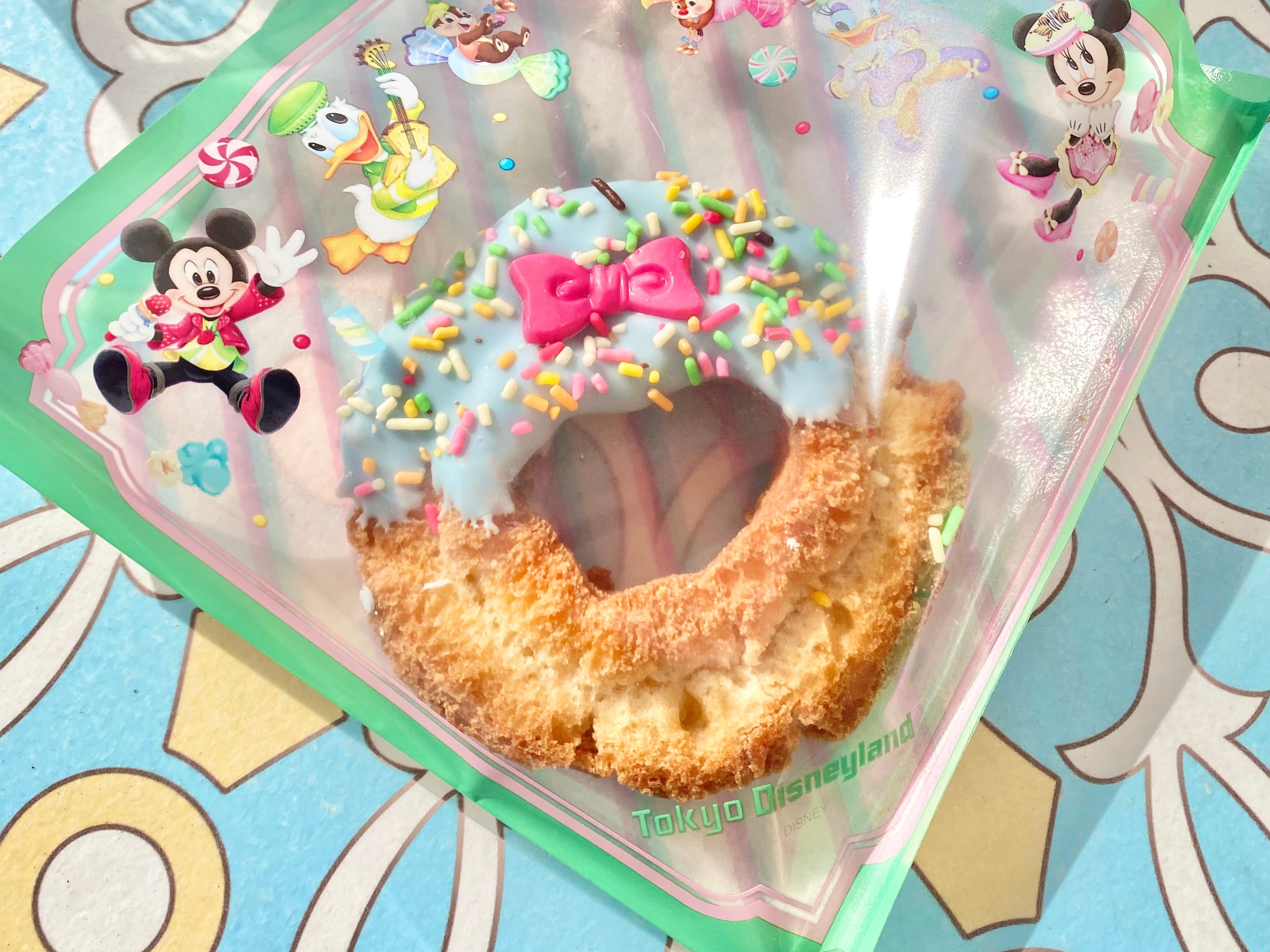 ドーナツ型の東京ディズニーランドのパイ、お菓子のトッピングとキャラクターの絵が描かれたカラフルな包装。