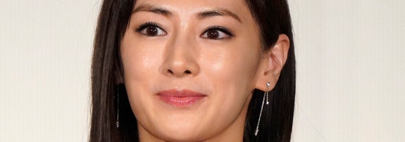 有名人が黒のエレガントなドレスを着て微笑んでいる。シンプルで洗練されたスタイル。