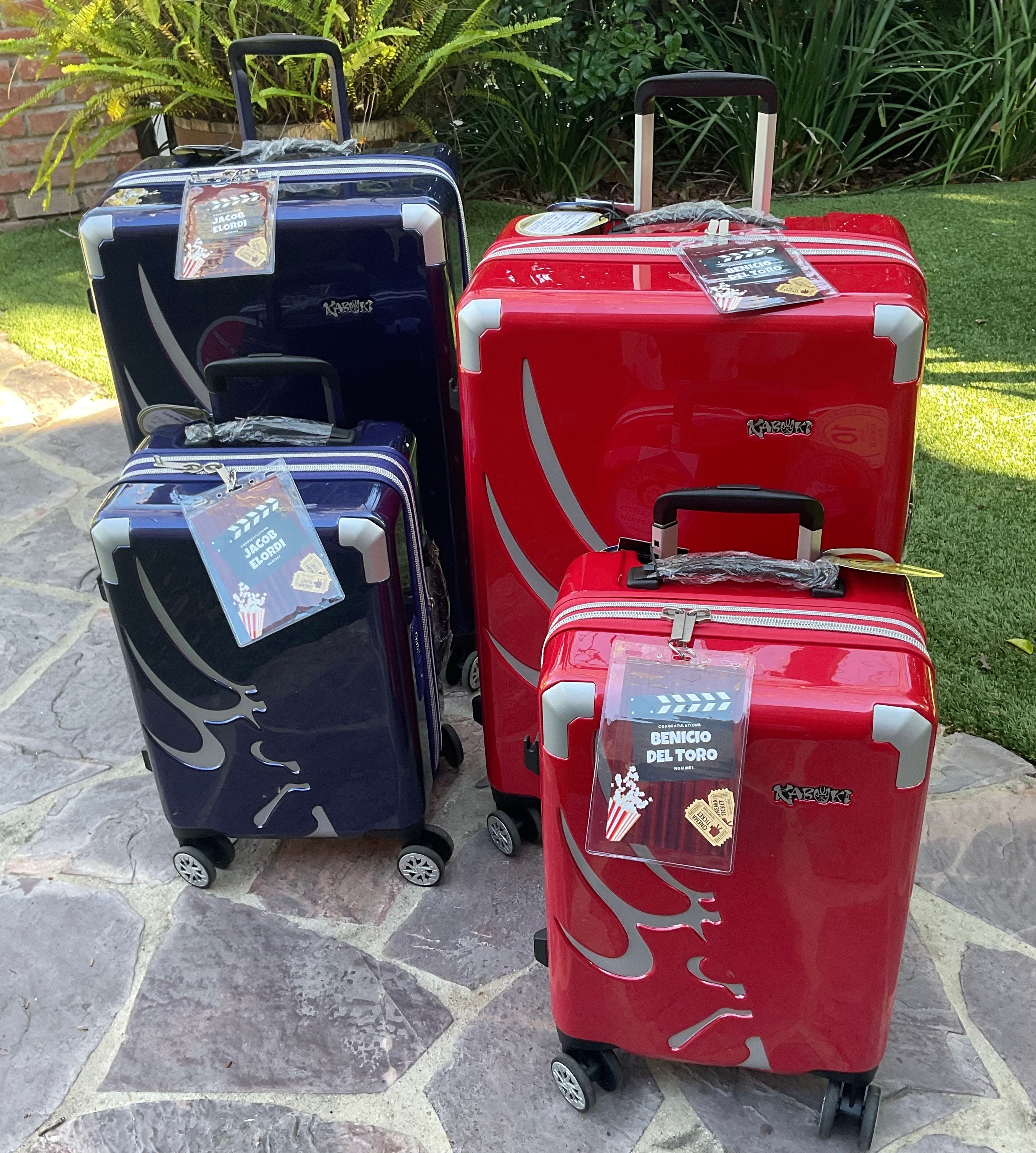 Four suitcases with movie-themed tags beryllium   connected  a chromatic  way  outdoors, surrounded by greenery