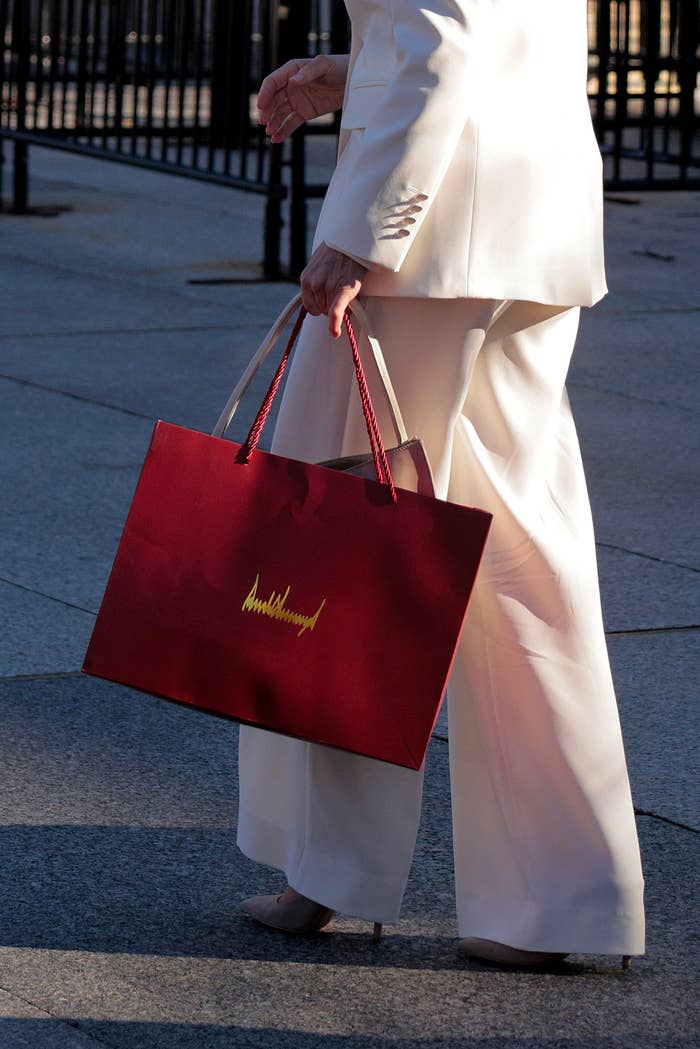 Venezuelan opposition leader and Nobel Peace Prize winner María Corina Machado carries a gift bag with President Donald Trump's signature on it outside the White House; the image only depicts her from the waist down
