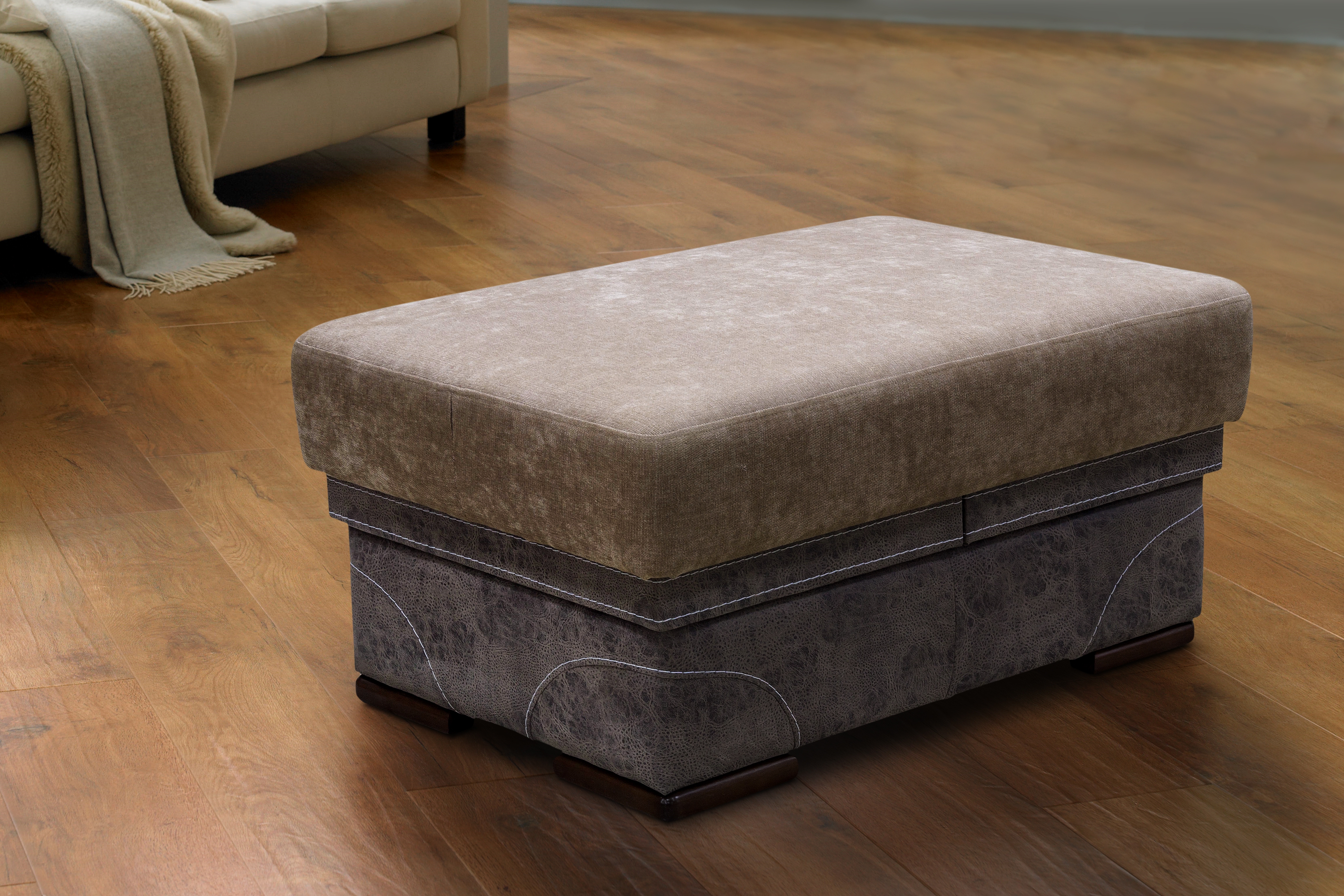 Ottoman successful  a surviving  country   with woody  floor, adjacent   a beige sofa with a draped blanket