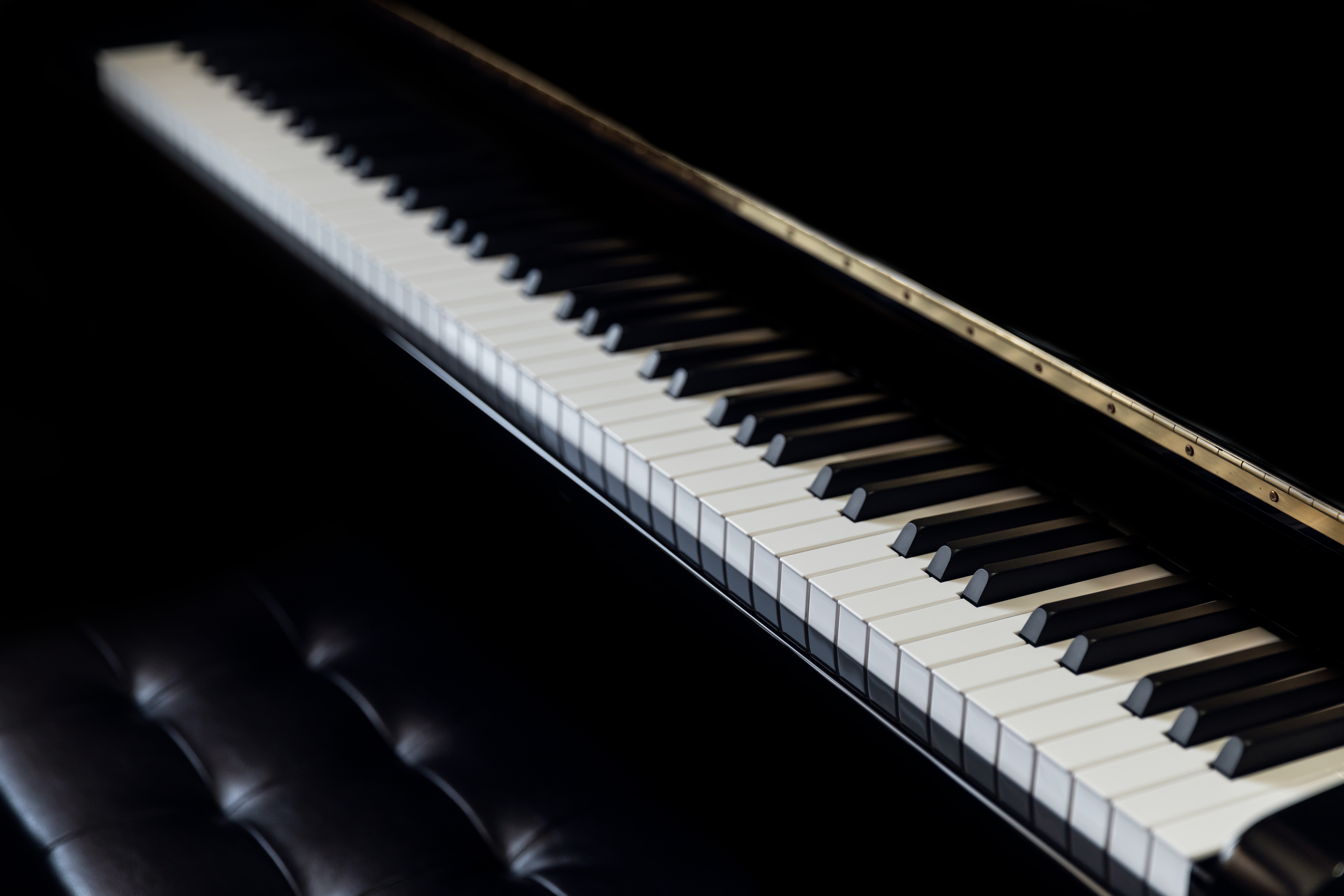 A expansive  soft  keyboard with a matching achromatic  seat  successful  a dimly lit setting