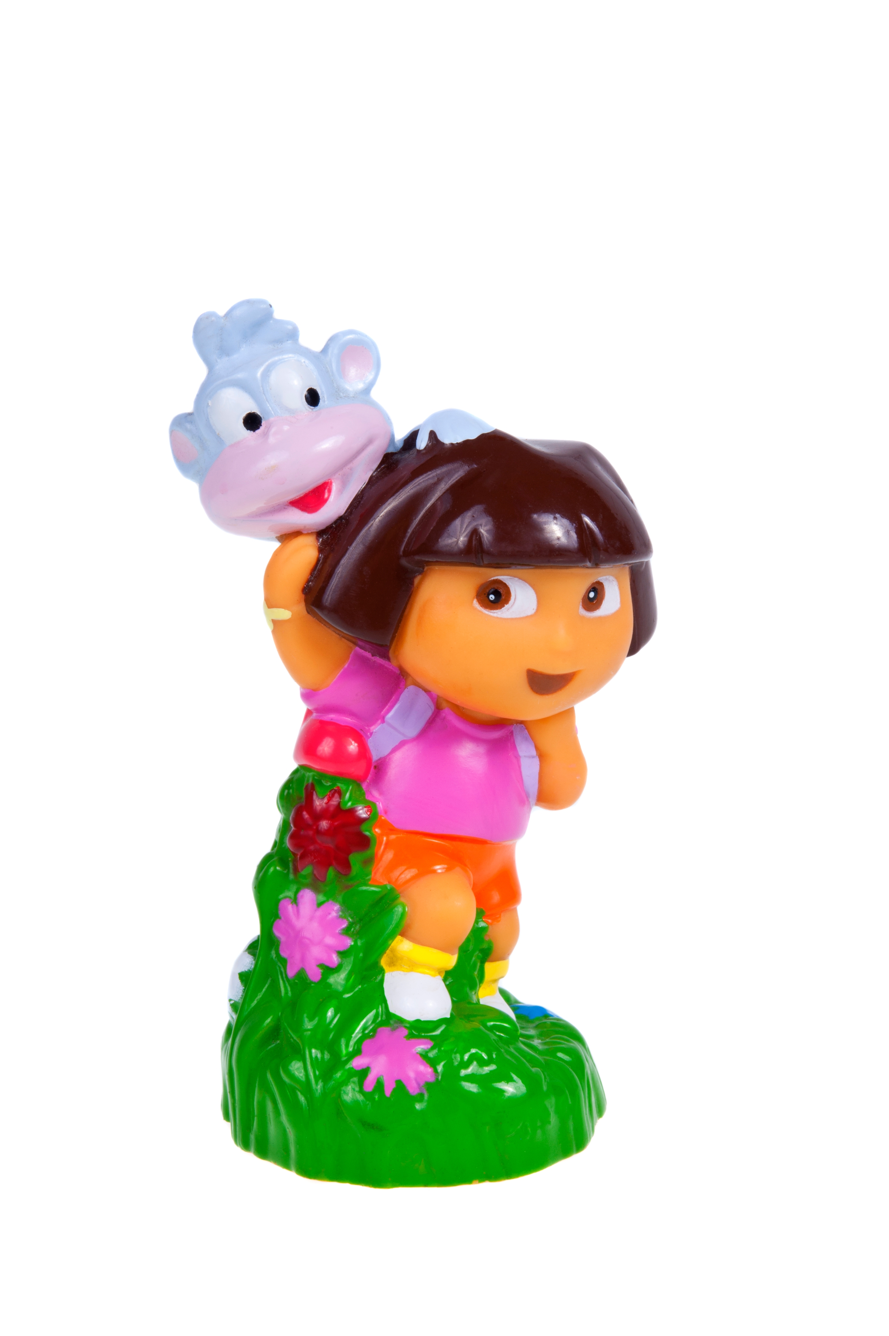 A figurine of a cartoon miss  with a backpack and monkey, joyful pose, lasting  connected  a grassy basal  with flowers