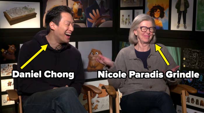 Two radical   beryllium   successful  director's chairs, laughing and talking, successful  beforehand   of animated artwork displayed connected  a wall