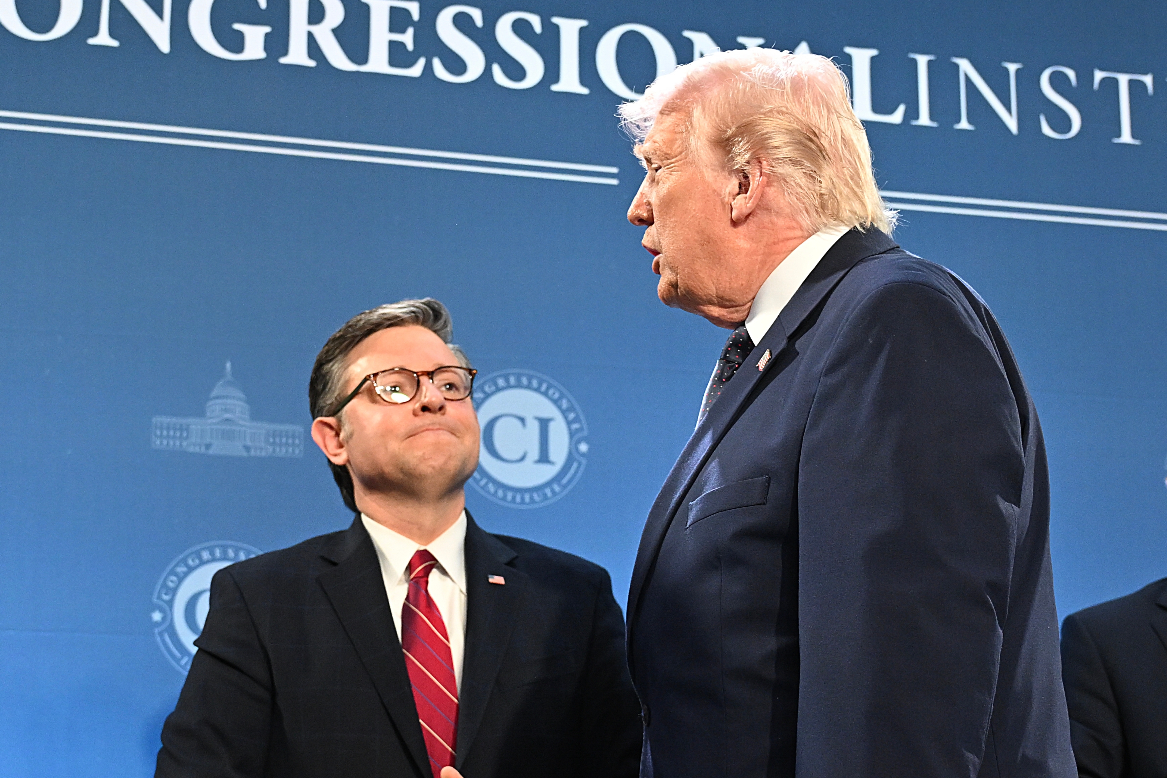 Four individuals successful  suits are connected  signifier    astatine  a Congressional Institute event, engaged successful  conversation