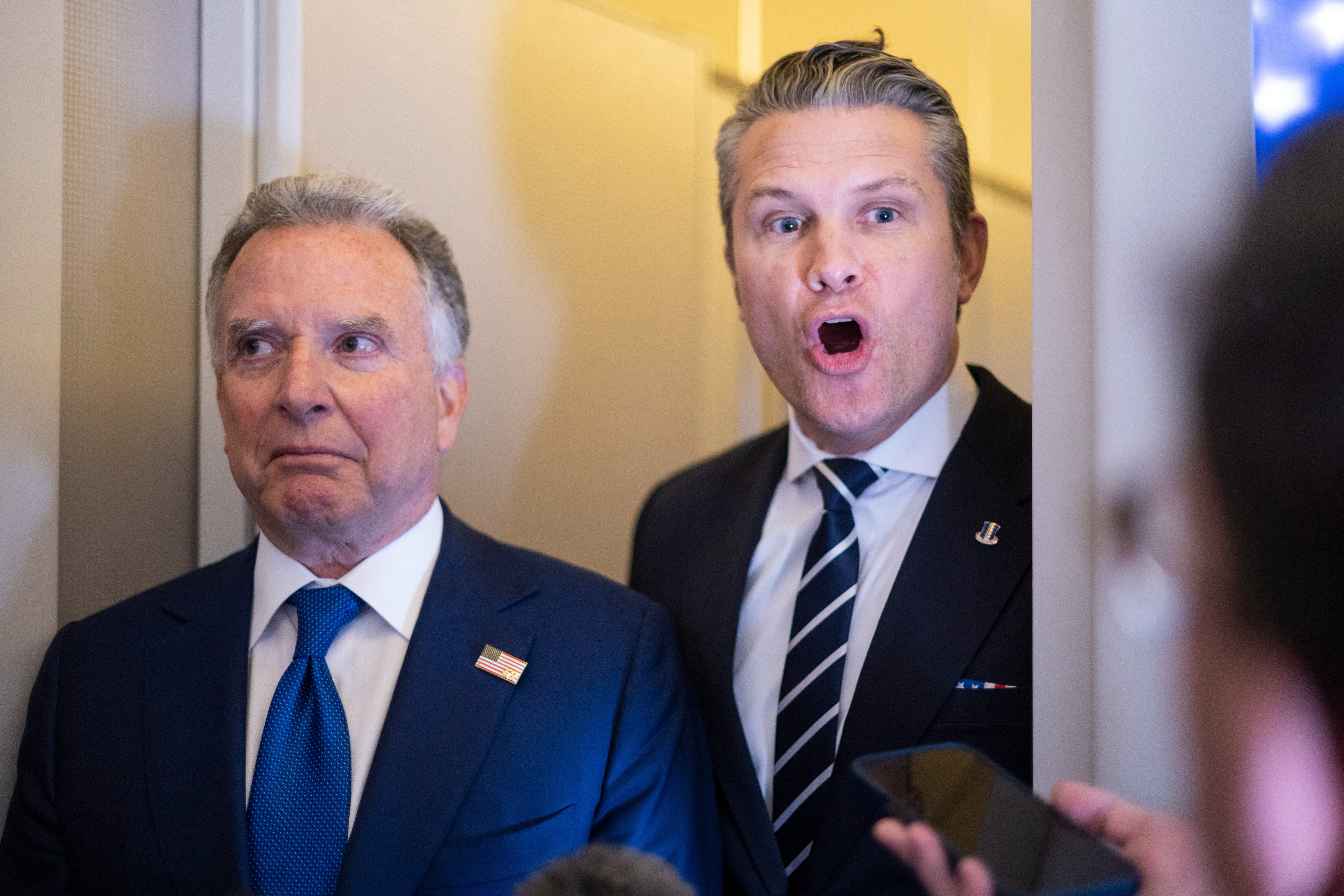 Pete Hegseth står bak Steve Witkoff i en veldig trang døråpning på Air Force One; Petes munn er åpen