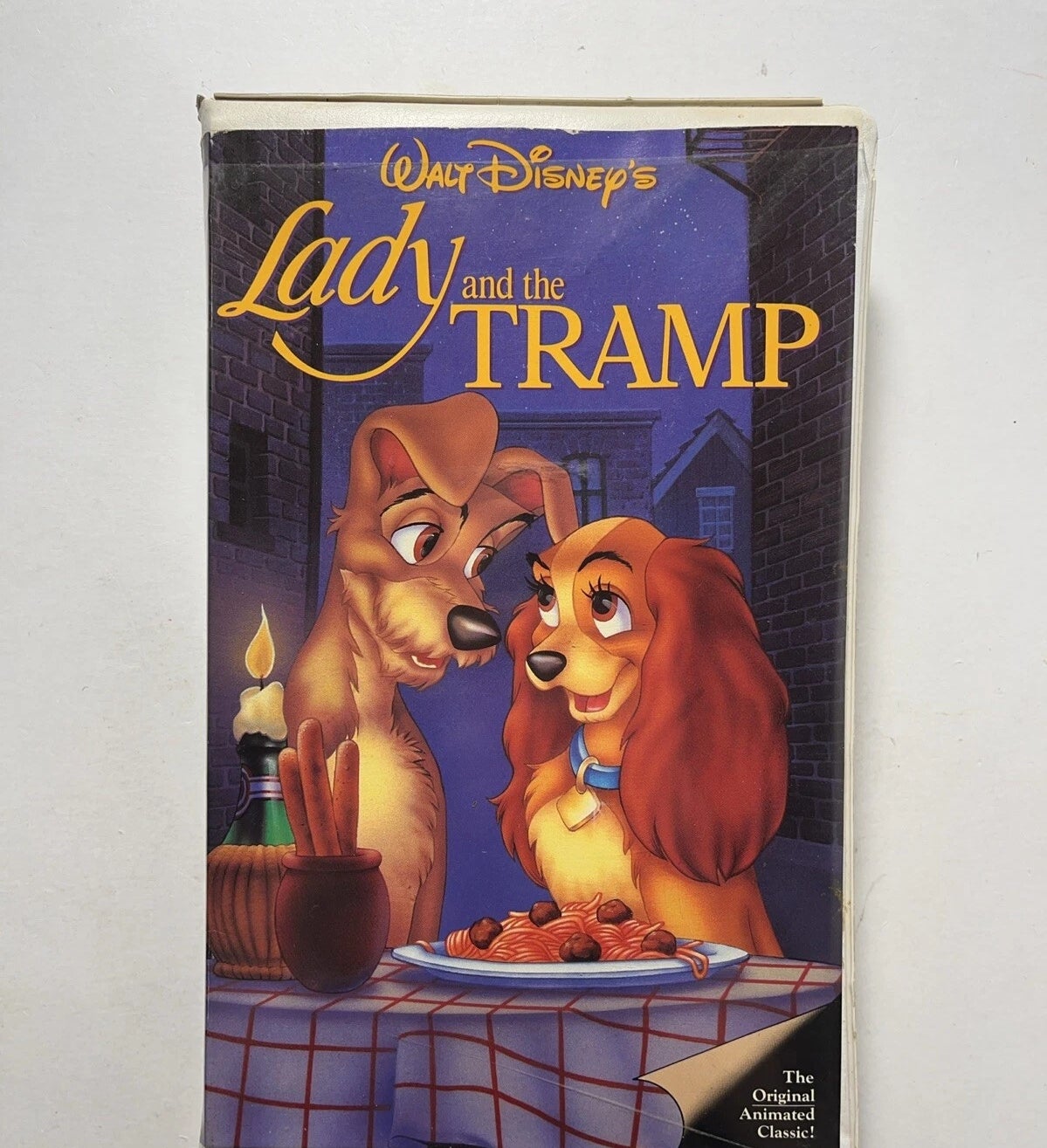 Cover of "Lady and the Tramp" VHS showing the 2  dogs astatine  a candlelit meal  with spaghetti