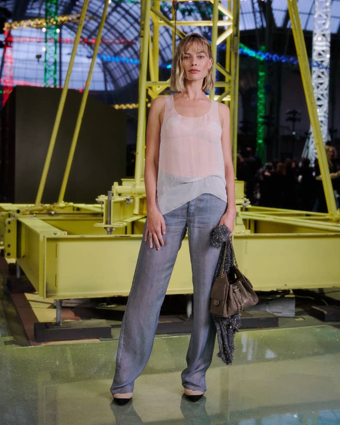 Margot Robbie successful  a sheer apical  and wide-legged pants stands successful  beforehand   of modern   creation  installation
