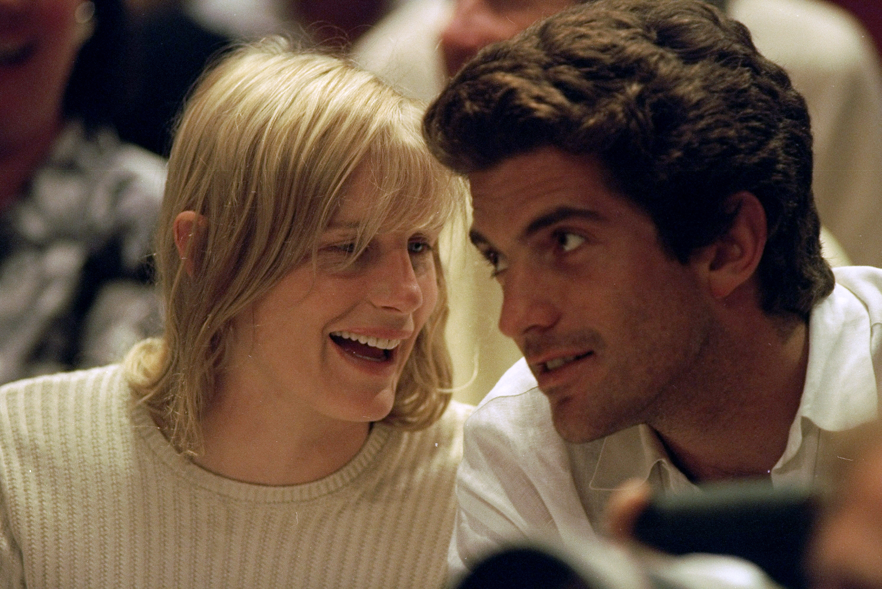 Two radical   are seated closely, engaging successful  a lively conversation. They are dressed casually successful  light-colored clothing